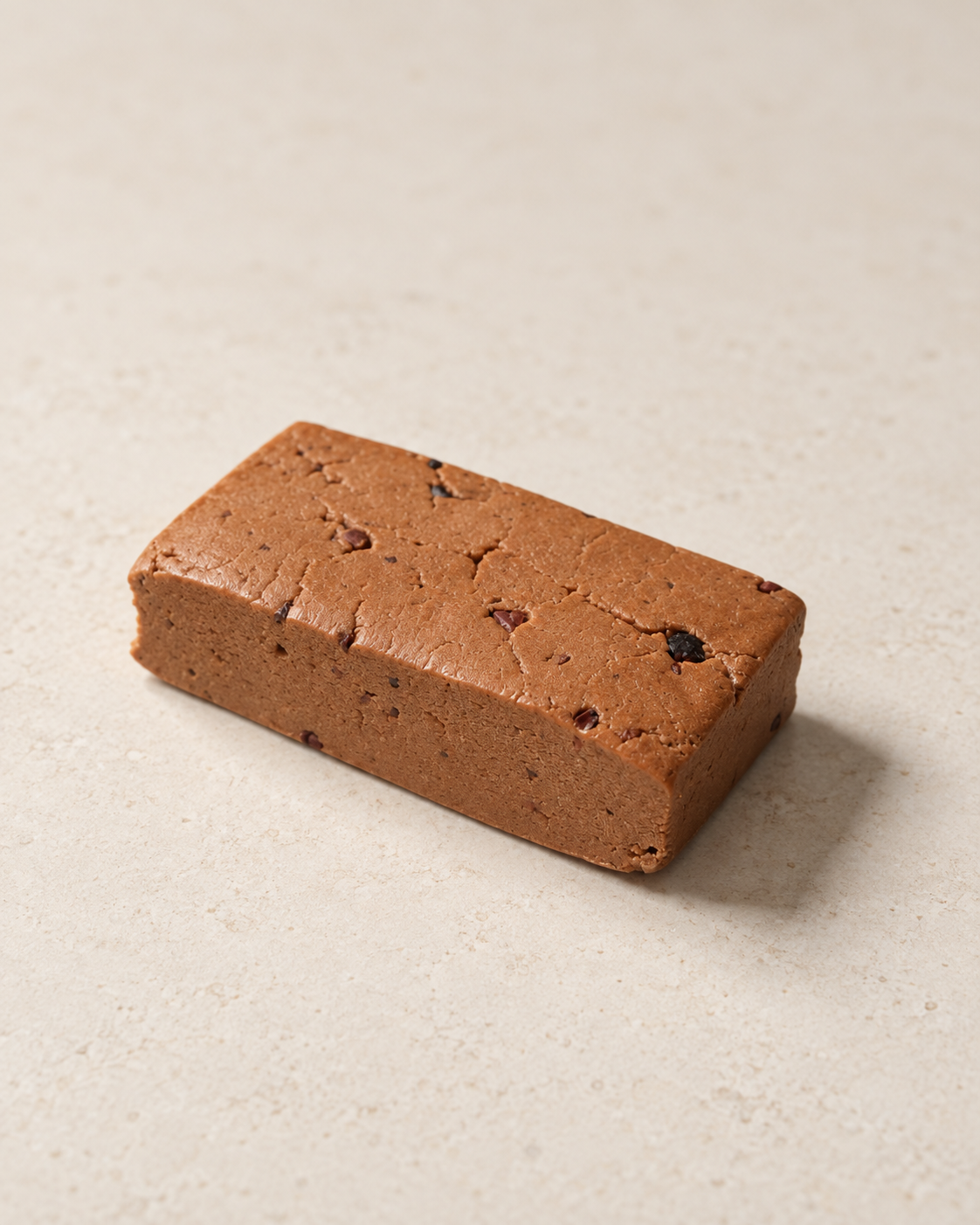 Unwrapped Dark Cacao bar showing its dense texture and cacao nibs